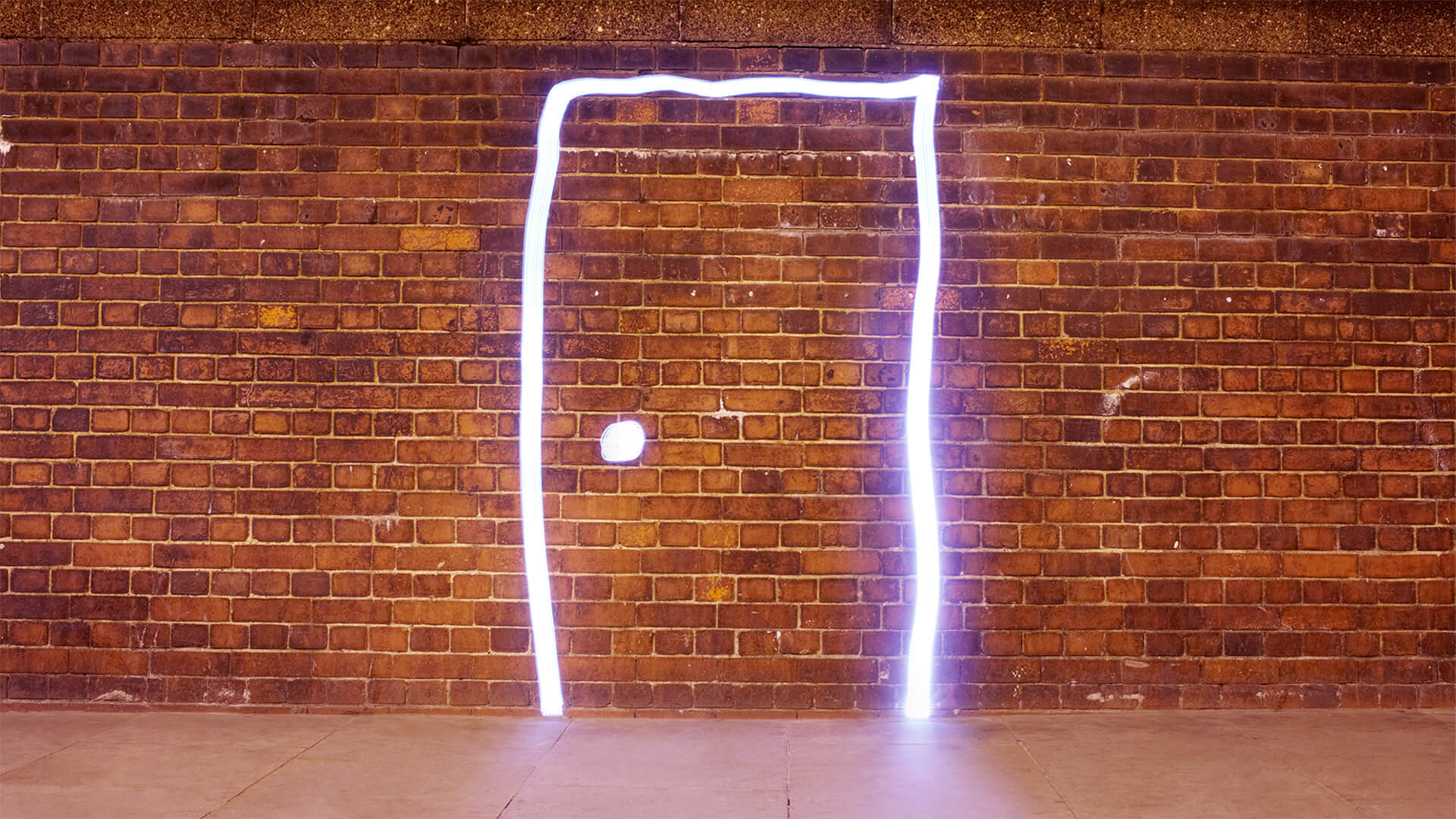   A brick wall with the bright outlines of a door